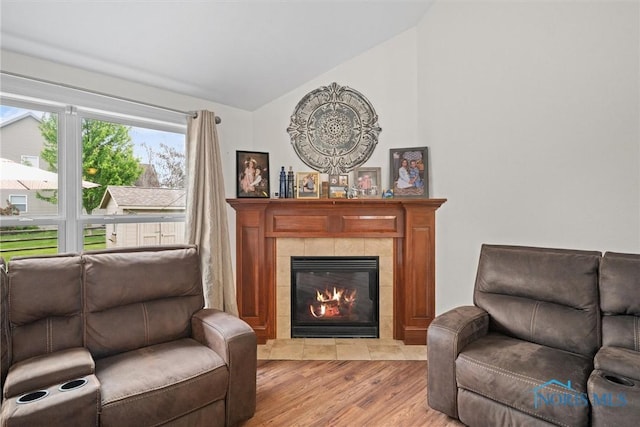 12158 Jefferson St, Perrysburg, OH 43551 - living room featuring vaulted ceiling, light wood-style floors, and a tiled fireplace