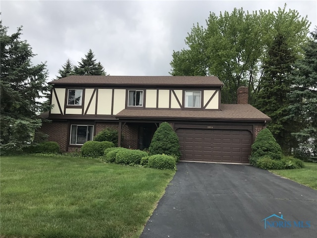 2024 Inglewood Rd, Holland, OH 43528 - tudor house featuring brick siding, a front yard, asphalt driveway, and stucco siding