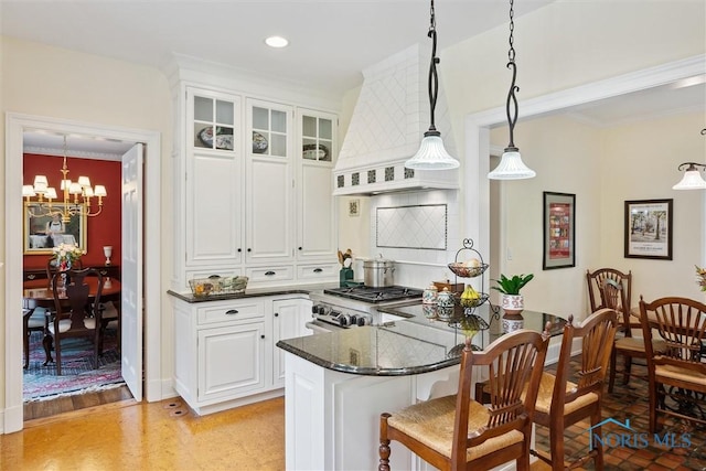 3534 Edgevale Rd, Ottawa Hills, OH 43606 - kitchen featuring stove, custom exhaust hood, a kitchen breakfast bar, a chandelier, and white cabinetry