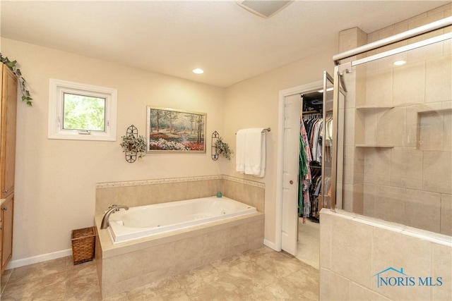 7915 W Bancroft St, Toledo, OH 43617 - full bathroom with a whirlpool tub, a stall shower, a walk in closet, tile patterned flooring, and baseboards