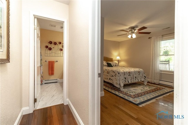 7915 W Bancroft St, Toledo, OH 43617 - bedroom featuring baseboard heating, dark wood-style flooring, and baseboards