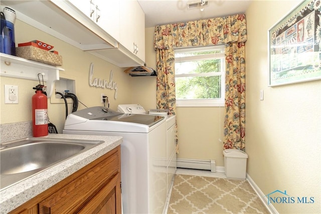 7915 W Bancroft St, Toledo, OH 43617 - laundry area with baseboard heating, cabinet space, separate washer and dryer, and baseboards