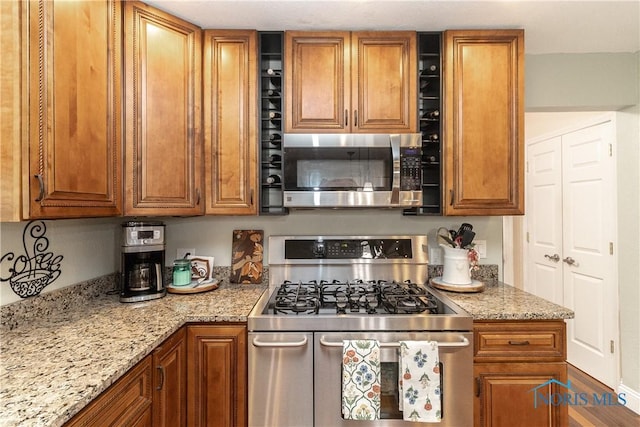 7915 W Bancroft St, Toledo, OH 43617 - kitchen featuring stainless steel appliances, brown cabinets, and light stone counters