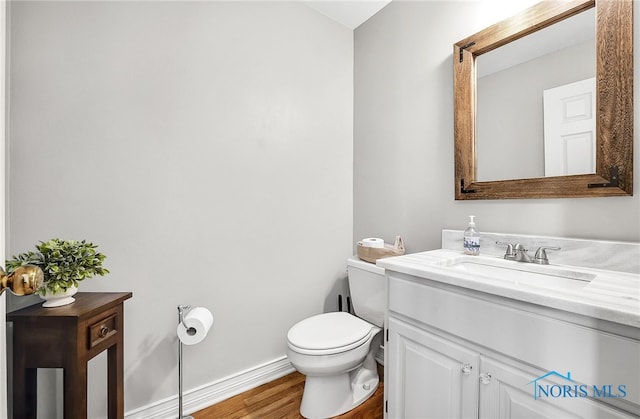 8832 Orchard Lake Rd, Holland, OH 43528 - bathroom featuring vanity, wood finished floors, toilet, and baseboards