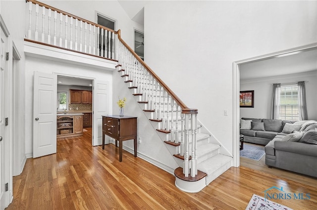 8832 Orchard Lake Rd, Holland, OH 43528 - stairs featuring wood finished floors, baseboards, a towering ceiling, and crown molding