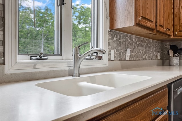 8832 Orchard Lake Rd, Holland, OH 43528 - kitchen featuring a sink, brown cabinets, light countertops, decorative backsplash, and stainless steel dishwasher