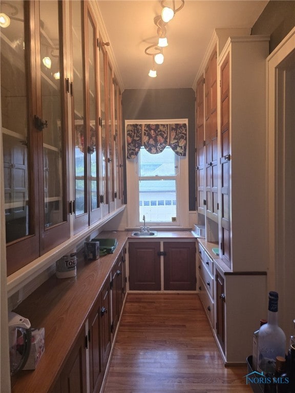 2267 Robinwood Ave, Toledo, OH 43620 - kitchen with a sink, dark wood-style floors, glass insert cabinets, and light countertops