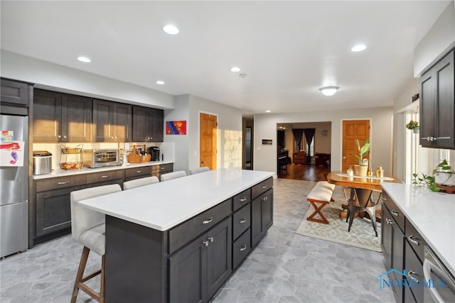 25581 Normandy Rd, Perrysburg, OH 43551 - kitchen with stainless steel appliances, a center island, light countertops, a kitchen bar, and recessed lighting