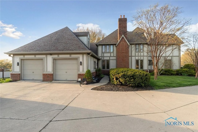 25581 Normandy Rd, Perrysburg, OH 43551 - view of front of house with brick siding, a garage, concrete driveway, a shingled roof, and a chimney
