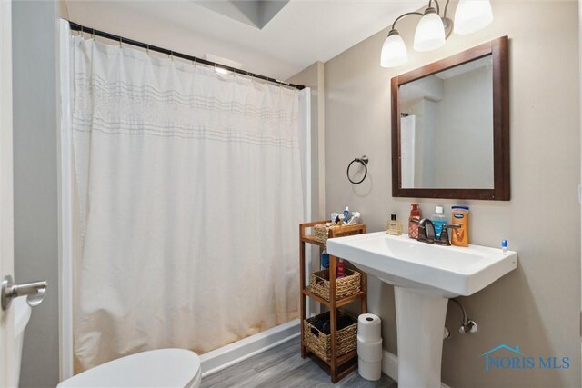 25581 Normandy Rd, Perrysburg, OH 43551 - full bathroom featuring toilet, wood finished floors, a shower with shower curtain, and baseboards