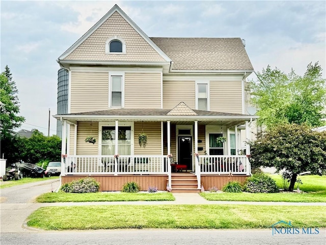 118 N Maple St, Hicksville, OH 43526 - victorian home featuring a porch, a front lawn, and a shingled roof