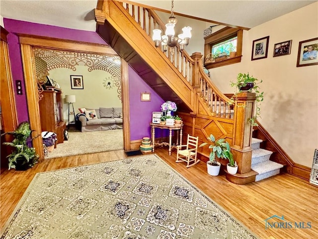 118 N Maple St, Hicksville, OH 43526 - stairway with wood finished floors, a chandelier, and baseboards