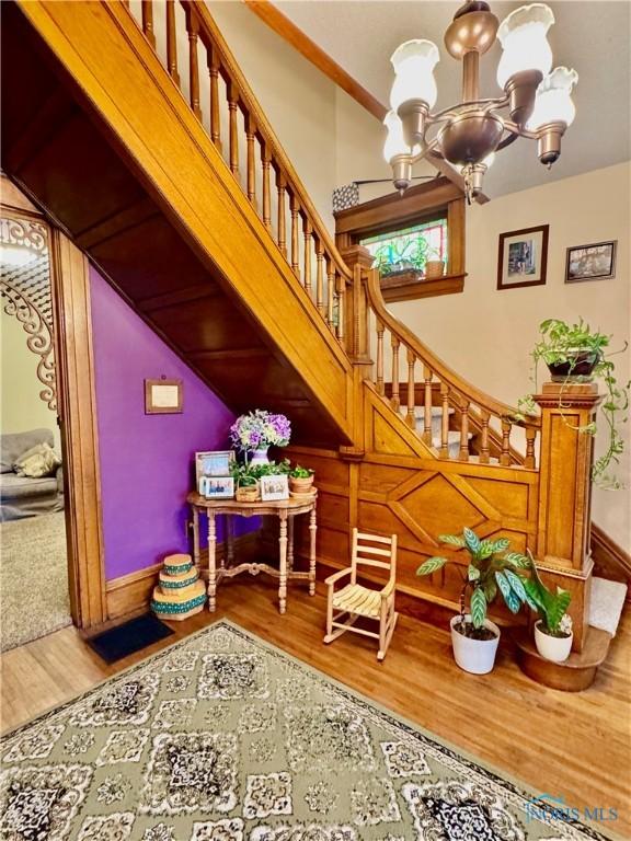 118 N Maple St, Hicksville, OH 43526 - stairway with wood finished floors, a chandelier, and baseboards
