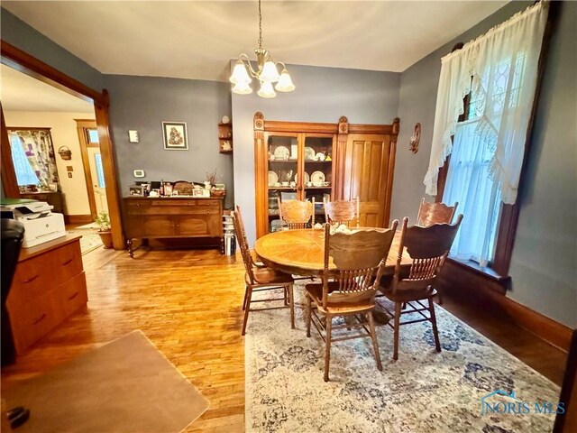 118 N Maple St, Hicksville, OH 43526 - dining area featuring wood finished floors, a chandelier, and baseboards