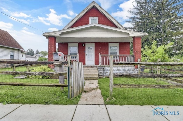 1528 Hirzel St, Toledo, OH 43605 - view of front of home featuring covered porch, brick siding, and a fenced front yard
