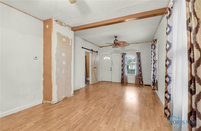 1528 Hirzel St, Toledo, OH 43605 - spare room featuring ceiling fan, light wood-type flooring, a barn door, and baseboards