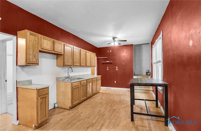 1528 Hirzel St, Toledo, OH 43605 - kitchen featuring a sink, ceiling fan, light countertops, light wood-type flooring, and baseboards