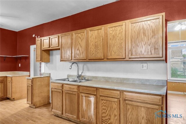1528 Hirzel St, Toledo, OH 43605 - kitchen with a sink, light wood-style floors, light countertops, and baseboards