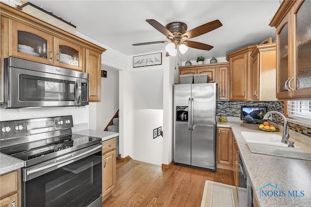 1796 Bucklew Dr, Toledo, OH 43613 - kitchen with stainless steel appliances, backsplash, a ceiling fan, light wood-style flooring, and glass insert cabinets