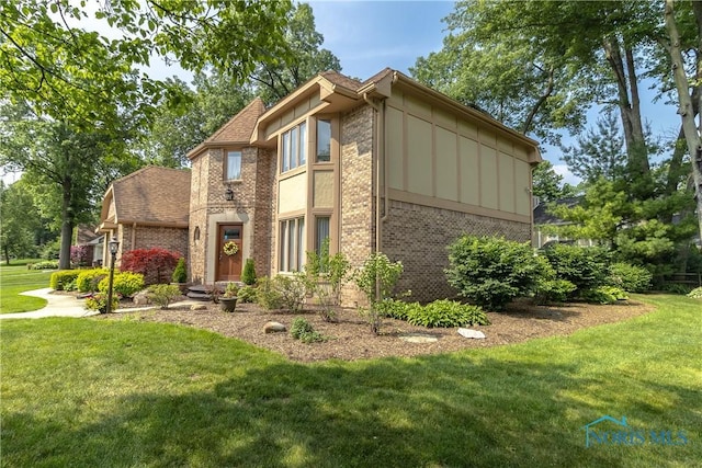 2439 Notting Hill Rd, Toledo, OH 43617 - view of front of home with brick siding, a front lawn, and board and batten siding
