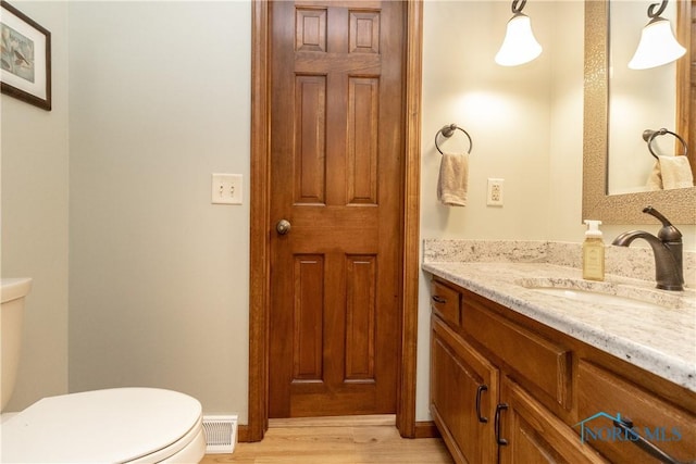 2439 Notting Hill Rd, Toledo, OH 43617 - bathroom featuring toilet, vanity, and wood finished floors