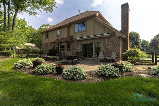 2439 Notting Hill Rd, Toledo, OH 43617 - back of house with a chimney, a patio, and brick siding