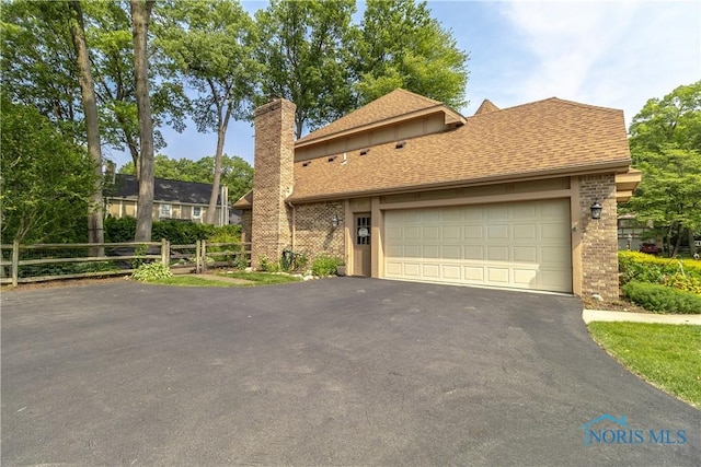 2439 Notting Hill Rd, Toledo, OH 43617 - view of front of house featuring asphalt driveway, an attached garage, a chimney, and a shingled roof