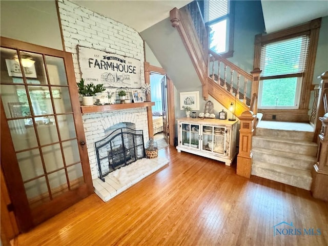 1520 S Clinton St, Defiance, OH 43512 - living area featuring stairs, wood finished floors, a brick fireplace, and lofted ceiling