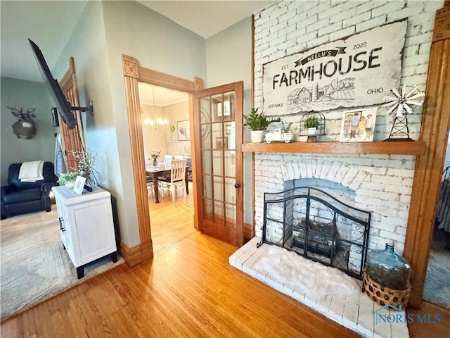 1520 S Clinton St, Defiance, OH 43512 - living area with wood finished floors, a chandelier, a fireplace, and baseboards