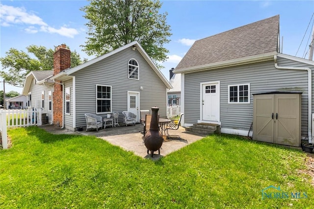 254 N Worthy St, Marblehead, OH 43440 - rear view of house with entry steps, a patio, a chimney, roof with shingles, and an outbuilding