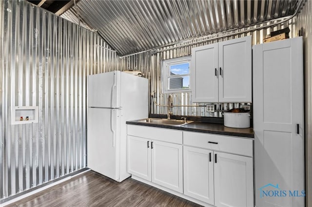 254 N Worthy St, Marblehead, OH 43440 - kitchen with freestanding refrigerator, dark countertops, vaulted ceiling, white cabinetry, and dark wood-style floors