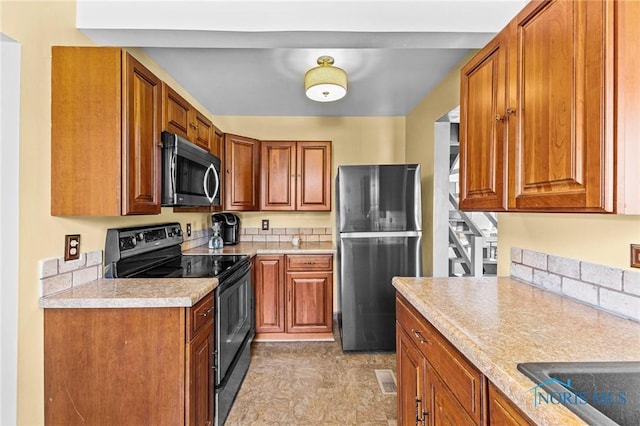 254 N Worthy St, Marblehead, OH 43440 - kitchen featuring stainless steel appliances, light countertops, and brown cabinetry