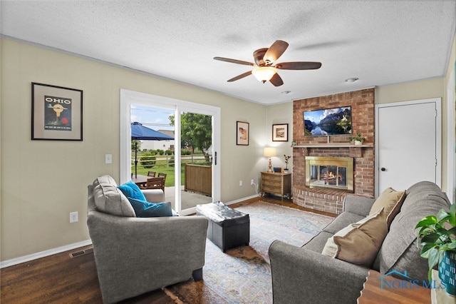 826 Touraine Ave, Bowling Green, OH 43402 - living area featuring a ceiling fan, wood finished floors, a brick fireplace, baseboards, and a textured ceiling
