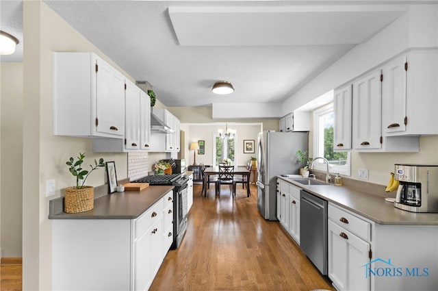 826 Touraine Ave, Bowling Green, OH 43402 - kitchen with appliances with stainless steel finishes, a sink, white cabinets, wood finished floors, and a chandelier