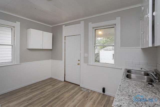426 Arden Pl, Toledo, OH 43605 - kitchen with a sink, ornamental molding, white cabinets, light wood-style flooring, and light countertops