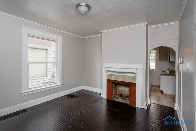 426 Arden Pl, Toledo, OH 43605 - unfurnished living room featuring a tile fireplace, ornamental molding, wood finished floors, arched walkways, and baseboards