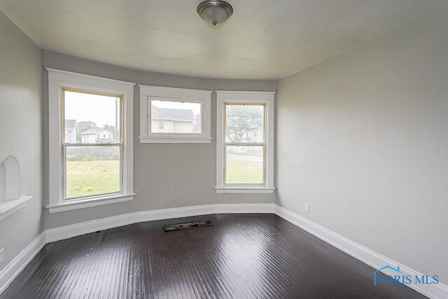 426 Arden Pl, Toledo, OH 43605 - empty room featuring dark wood-style floors, baseboards, and healthy amount of natural light
