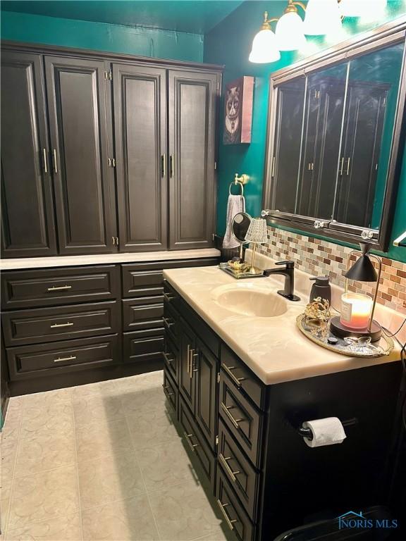 314 Jewett Ave, North Baltimore, OH 45872 - bathroom featuring backsplash, vanity, and tile patterned flooring