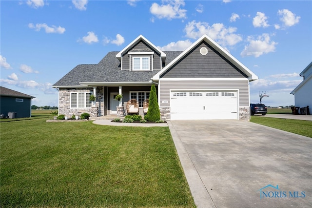 1209 Apache Dr, Wauseon, OH 43567 - craftsman inspired home with stone siding, a front yard, driveway, a porch, and an attached garage