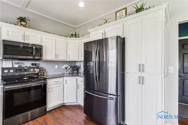 1209 Apache Dr, Wauseon, OH 43567 - kitchen featuring stainless steel appliances, dark stone countertops, dark wood-style floors, and backsplash