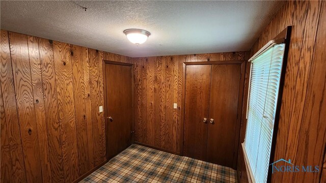 2384 State Route 109, Delta, OH 43515 - unfurnished bedroom featuring wooden walls and a textured ceiling