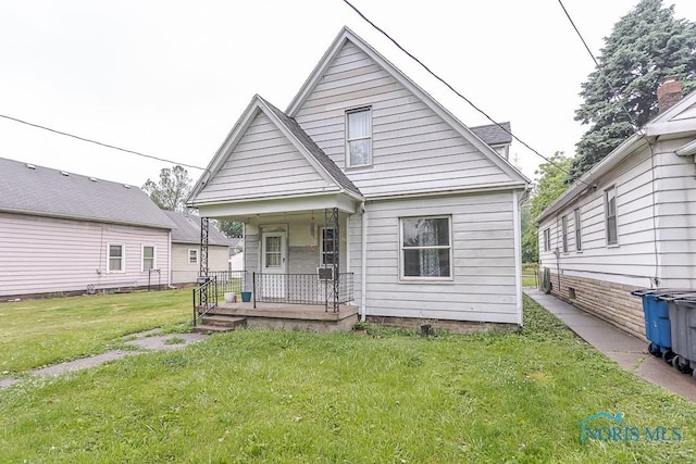 2721 Fremont St, Toledo, OH 43605 - shotgun-style home featuring covered porch and a front yard