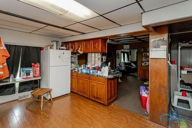 2602 Fremont St, Toledo, OH 43605 - kitchen featuring freestanding refrigerator, brown cabinets, light wood-style floors, and dark countertops