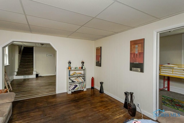 635 Plymouth St, Toledo, OH 43605 - unfurnished room with wood finished floors, baseboards, stairs, arched walkways, and a paneled ceiling