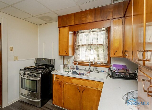 1215 Starr Ave, Toledo, OH 43605 - kitchen featuring stainless steel gas range oven, light countertops, a sink, brown cabinets, and a drop ceiling