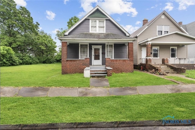 1617 Buckingham St, Toledo, OH 43607 - view of front of home featuring a porch, a front lawn, and brick siding