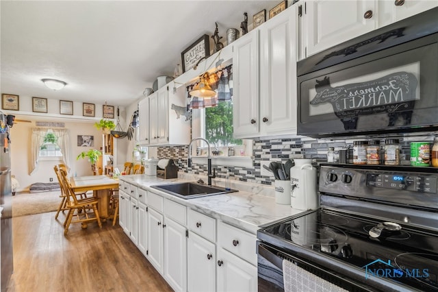 8399 W State Route 12, Fostoria, OH 44830 - kitchen with black appliances, a sink, white cabinets, and plenty of natural light
