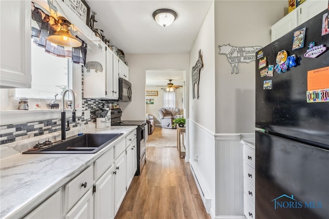 8399 W State Route 12, Fostoria, OH 44830 - kitchen with black appliances, a sink, white cabinetry, tasteful backsplash, and light wood finished floors