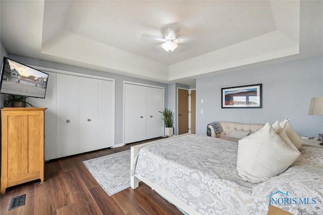 2543 Broadway St Unit 2543, Toledo, OH 43609 - bedroom featuring a raised ceiling, dark wood-type flooring, two closets, and ceiling fan