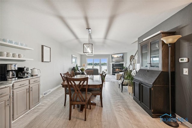 2543 Broadway St Unit 2543, Toledo, OH 43609 - dining space featuring light wood-style flooring, a glass covered fireplace, and baseboards